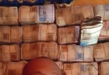 Bandit displaying huge cash haul he collected as ransom.