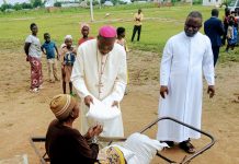 Bishop Mamza giving a vulnerable woman food items in commemoration of the WDMR at Salama housing on Thursday.
