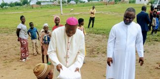 Bishop Mamza giving a vulnerable woman food items in commemoration of the WDMR at Salama housing on Thursday.
