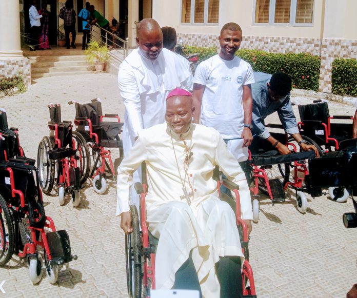 Bishop Mamza mounted one of the wheelchairs to showcase its strength during the distribution of 93 wheelchairs to PLWD on Tuesday in Yola.