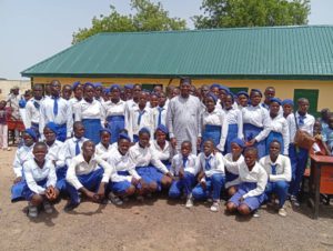 A historic picture of the senator sandwiched between students of GDSS Kpasham shortly after commissioning of three reconstructed classrooms on Thursday.