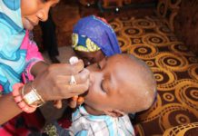 A file picture of a woman administration a oral polio vaccine on a child.