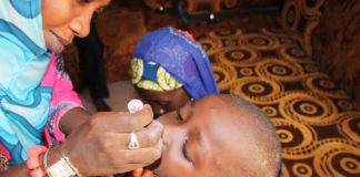 A file picture of a woman administration a oral polio vaccine on a child.