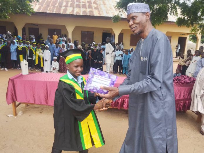 Prof Idi presenting award to one of the high flying students during the speech and prize giving day on Sunday at the school premises in Yolde Pate.