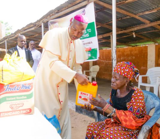 Mamza distributing the items to a victim of the clash.