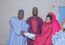 Commissioner of Health Jigawa State Dr Mohammed Abdullahi Kainuwa presenting a gift to some nursing students.