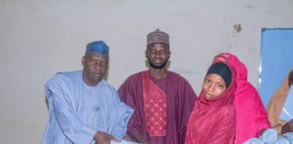 Commissioner of Health Jigawa State Dr Mohammed Abdullahi Kainuwa presenting a gift to some nursing students.