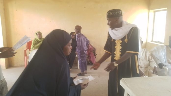 Ibrahim Abubakar Jimeta donating cash to a beneficiary on Sunday in Yola.