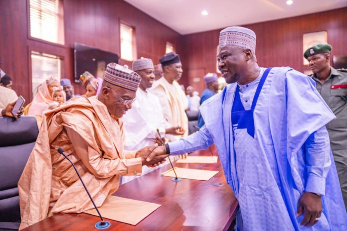 Sulaiman in a handshake with gov Fintiri after he was sworn-in as commissioner of works and energy development in Adamawa.