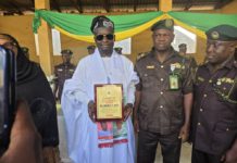 Dr. Emmanuel flanked by Correctional service staff with the award giving to him on Tuesday in Yola.