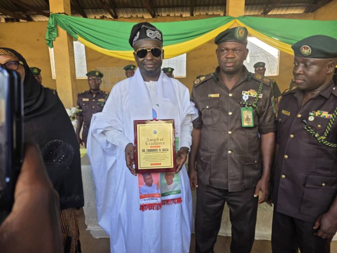 Dr. Emmanuel flanked by Correctional service staff with the award giving to him on Tuesday in Yola.